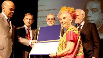 Elena Poniatowska recibe el premio R&oacute;mulo Gallegos de manos del vicepresidente de Venezuela, doctor Jorge Rodr&iacute;guez. Observan, de izquierda a derecha, el ministro del Poder Popular para la Cultura, arquitecto Francisco Sesto Nov&aacute;s, el presidente del Celarg, Roberto Hern&aacute;ndez Montoya, y el presidente del jurado de esta edici&oacute;n, el escritor Luis Britto Garc&iacute;a