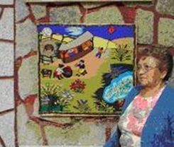 La se&ntilde;ora Pur&iacute;sima Ibarra junto a una de sus obras